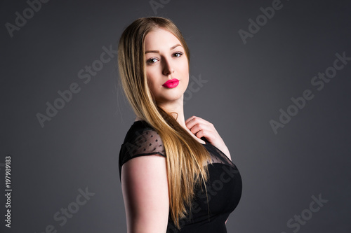 Plus size fashion model, sexy fat woman on gray studio background, overweight female body