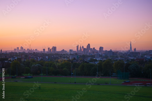View towards London city skyline at sunrise from parliament hill in Hampstead Heath