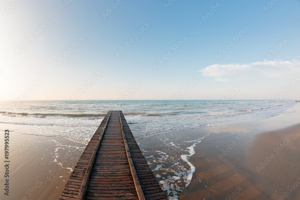 Obraz premium Wooden pier. Beach of Lido di Jesolo at adriatic Sea in a beautiful summer day Italy. near Venice. dense sea breeze at dawn