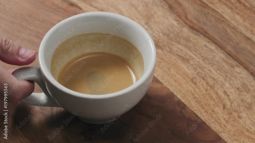Slow motion handheld shot of swirl espresso in cappuccino cup from above Slow motion handheld shot of swirl espresso in cappuccino cup from above