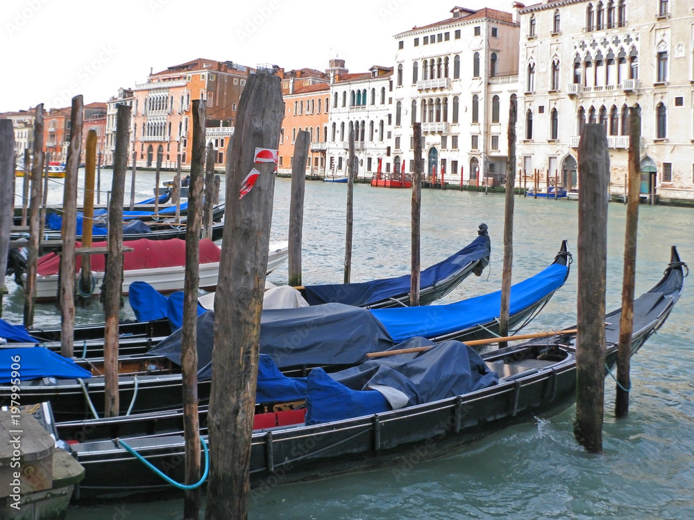 Venice. Italy. Large gondola boats are moored to the pier. On the other side of the canal are beautiful buildings.