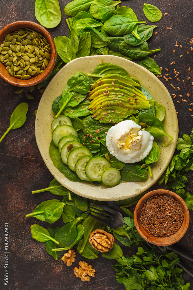 Green salad with spinach, cucumber, avocado, egg, flax and pumpkin seed. Food background. Detox Vegetarian Healthy Food Concept. Top view, copy space. Green salad with spinach, cucumber, avocado, egg, flax and pumpkin seed. Food background. Detox Vegetarian Healthy Food Concept. Top view, copy space.