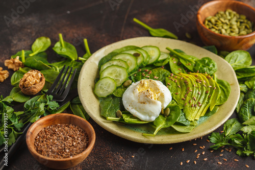 Green salad with spinach, cucumber, avocado, egg, flax and pumpkin seed. Food background. Detox Vegetarian Healthy Food Concept, copy space.