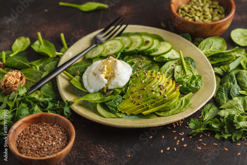 Green salad with spinach, cucumber, avocado, egg, flax and pumpkin seed. Food background. Detox Vegetarian Healthy Food Concept, copy space.