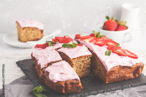 Yogurt pound cake for breakfast with pink glaze and fresh strawberries. Light background, summer dessert. Breakfast concept.