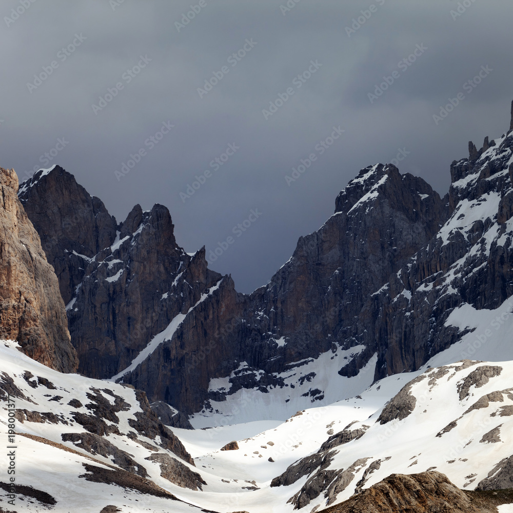 Snowy mountains and storm clouds