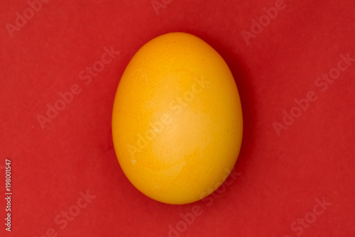 Yellow Easter egg on red background photo