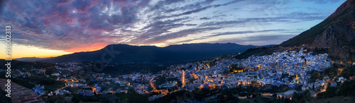 Panorama night city of Chefchaouen Morocco. Blue city in night lights. Journey through Morocco, magical place. Sunset over Chefchaouen, Morocco. Panoramic view of the city © angel_nt