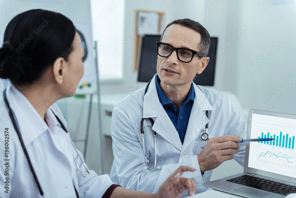 © Viacheslav Yakobchuk - Data analysis. Professiaonl pleasant doctors discussing the statistics while sitting at the table