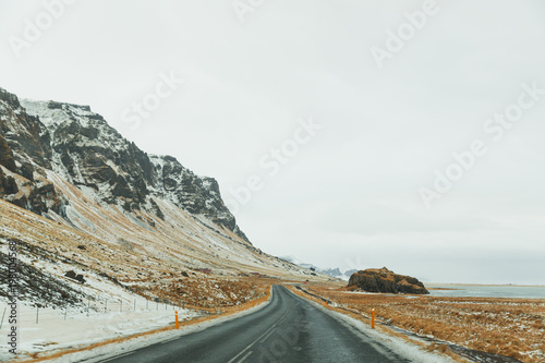 beautiful icelandic landscape with rocky hills and empty asphalt road