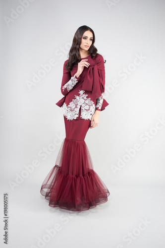 Attractive middle east female model wearing traditional dress.Dinner and eid mubarak fashion for Muslim Girl with grey background.