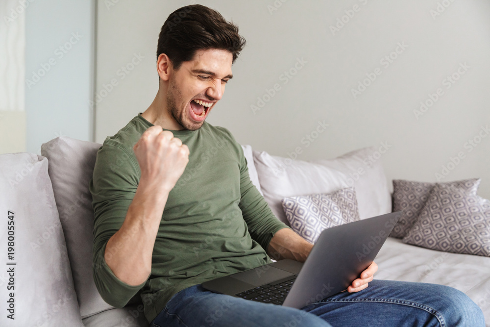 Excited young man using laptop Excited young man using laptop