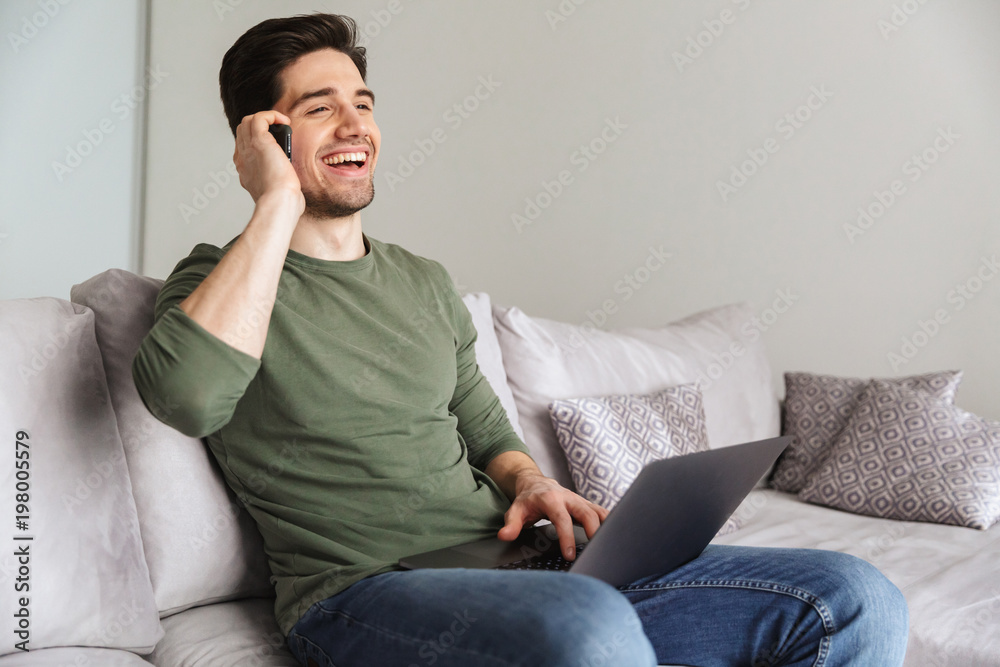 Smiling young man talking on mobile phone
