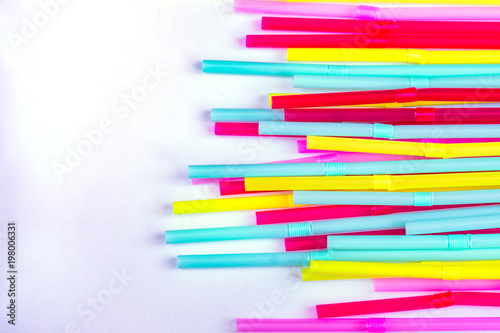blue, pink and yellow straws for cocktails and other drinks isolated on white background