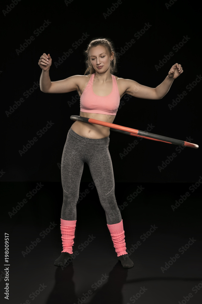 athletic woman holding hula hoop in her hands, isolated on the black background athletic woman holding hula hoop in her hands, isolated on the black background