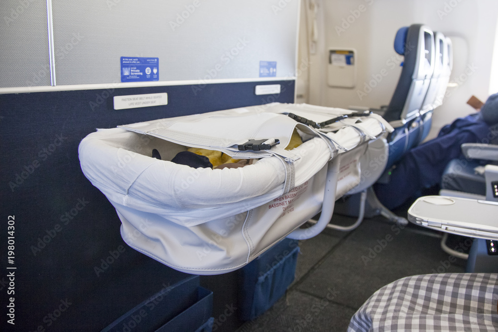 Baby sleeping in bassinet on airplane Stock Photo Adobe Stock
