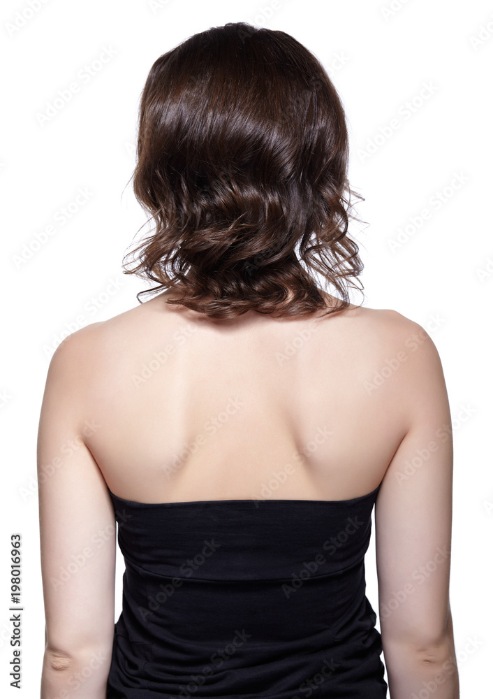 Brunette woman from backside on gray background Brunette woman from backside on gray background