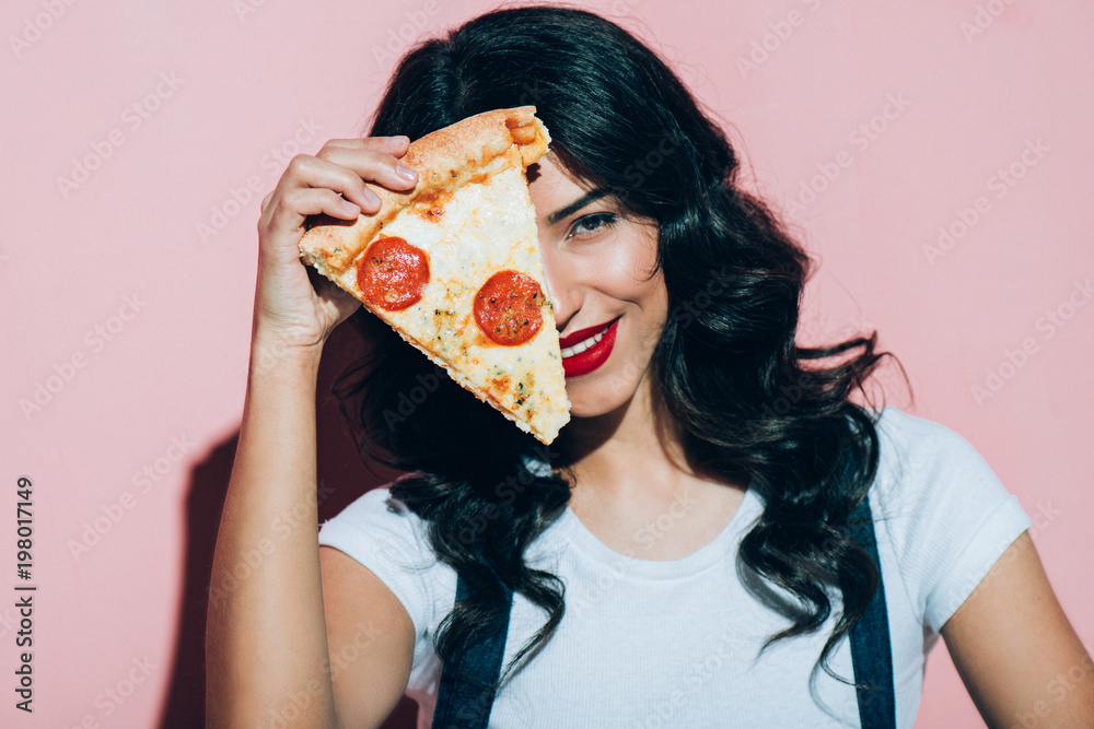 Φωτογραφία obscured view of beautiful smiling woman covering eye with piece of pizza on pin