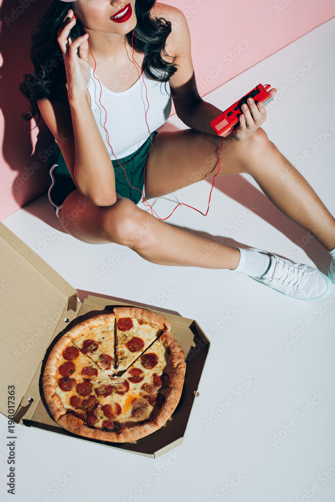 Φωτογραφία cropped shot of smiling woman with retro music player and delivery box with pizz