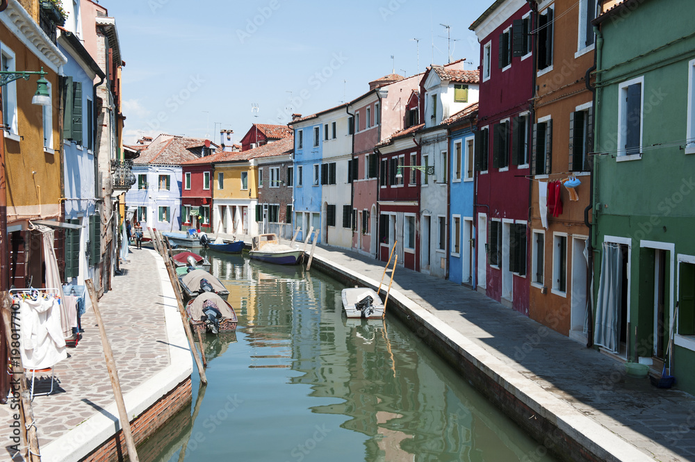 Burano, Venice- View of the canal and colorful houses in a sunny day
