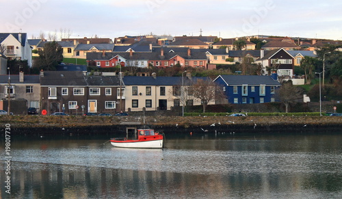 single boat floating in harbour photo