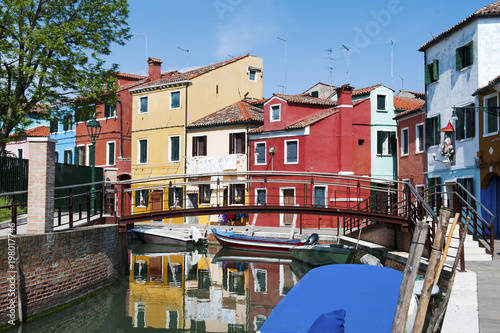 Brightly colorful houses reflected in the canal in Burano, a beautiful island in the Venetian lagoon near Venice, Italy