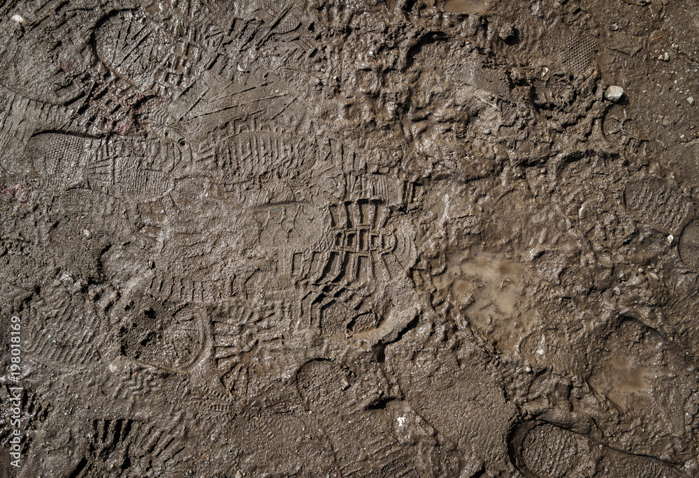 Wet ground with footprints. Mud ground with human footprints. Soil background Wet ground with footprints. Mud ground with human footprints. Soil background