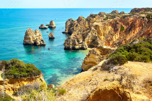 Fototapeta Naklejka Na Ścianę i Meble -  Cliff rocks and sea bay with turquoise water in Lagos, Algarve region, Portugal