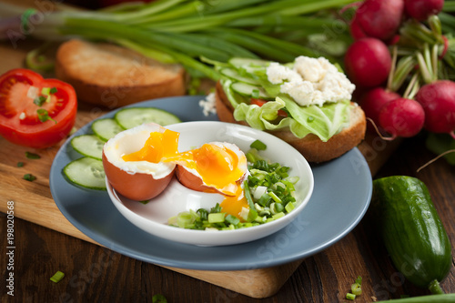 Boiled egg with crunchy bread and healthy vegetables for breakfast