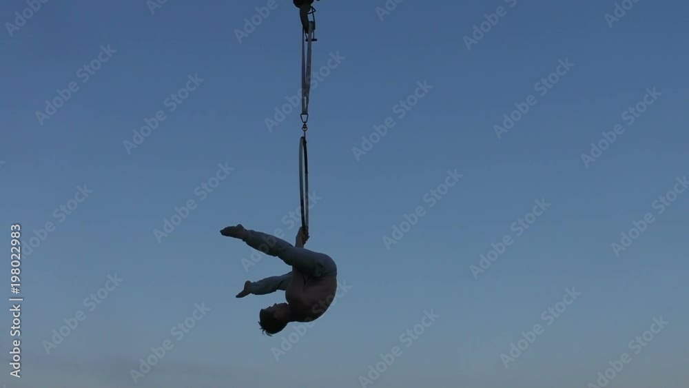 Man on the ring does gymnastic exercises high in the sky. Man on the ring does gymnastic exercises high in the sky.