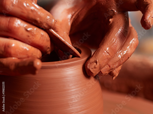 production process of pottery. Forming a clay teapot on a potter's wheel.