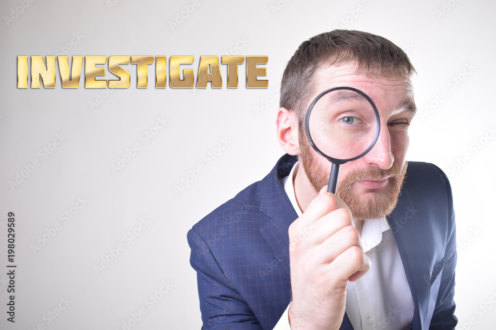 A businessman shows an inscription:INVESTIGATE A businessman shows an inscription:INVESTIGATE