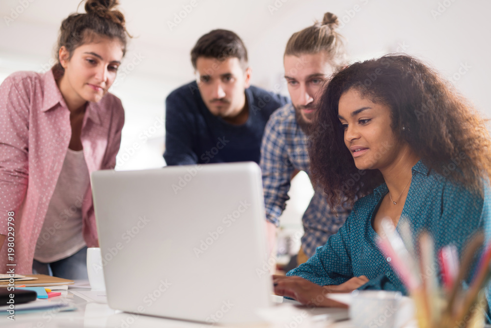 Multiracial group of students working on a common project Multiracial group of students working on a common project