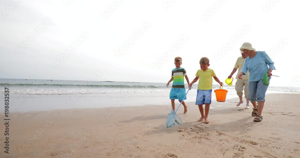 Slow motion shot of two brothers and their grandparents searching for shells on the beach. Slow motion shot of two brothers and their grandparents searching for shells on the beach.