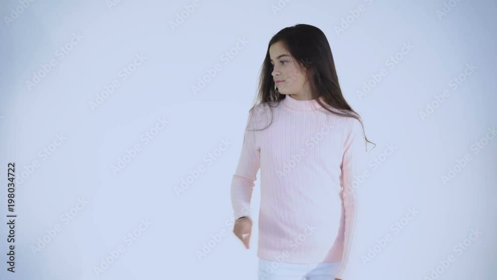 Pretty female teen rejoicing and dancing at camera on background Pretty female teen rejoicing and dancing at camera on background
