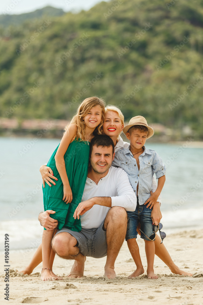 happy family on vacation embracing on beach and looking at camera happy family on vacation embracing on beach and looking at camera
