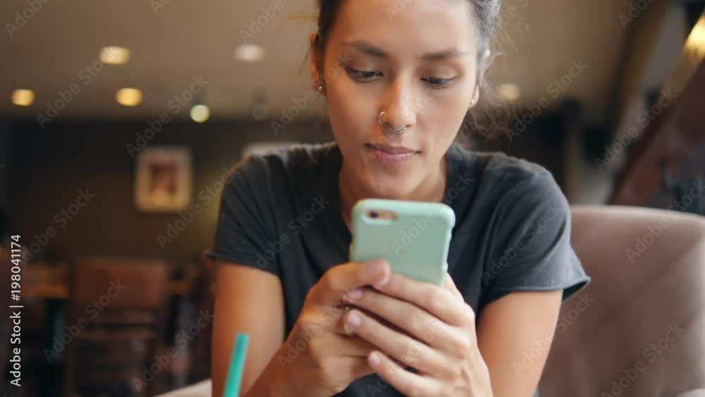 Young Mixed Race Woman Using Mobile Phone and Drinking Matcha Green tea in the Coffee Shop. 4K. Young Mixed Race Woman Using Mobile Phone and Drinking Matcha Green tea in the Coffee Shop. 4K.