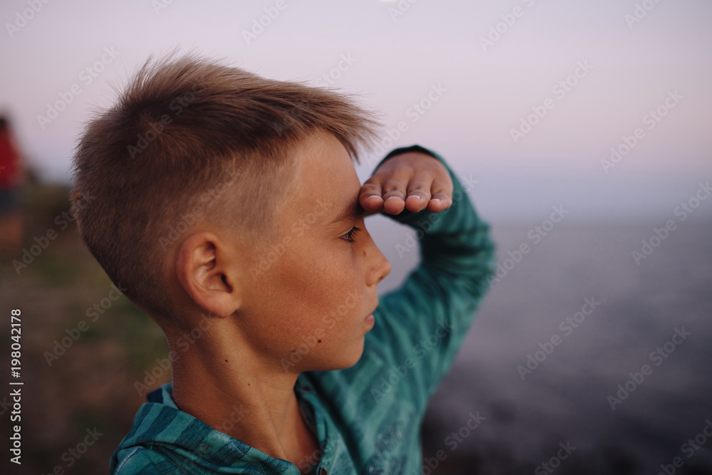 Portrait of boy, who look forward with raised hand, soft focus on eyes