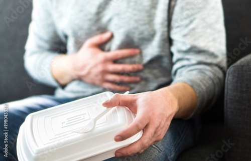 Man having diarrhea or food poisoning after unhealthy junk fast food. Guy has to go to toilet after eating too much. Stomach pain, digestion problem, indigestion, salmonella or heart attack concept.