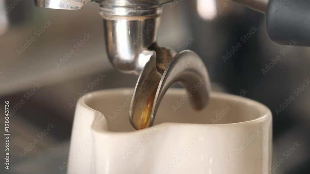Fresh Black Coffee Pouring from Professional Machine Dispenser in Cup. 4K, Macro Slowmotion. Fresh Black Coffee Pouring from Professional Machine Dispenser in Cup. 4K, Macro Slowmotion.