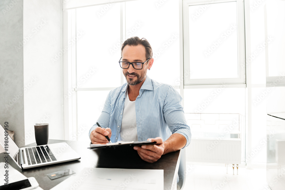 Fototapeta premium Handsome mature man working with documents