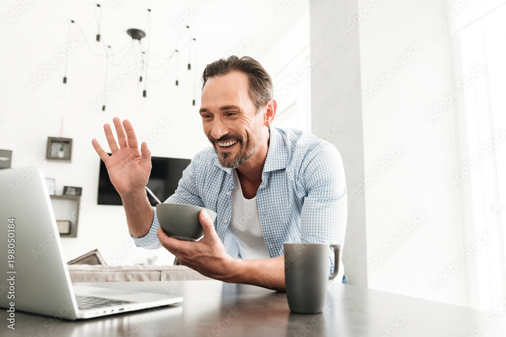 Fototapeta premium Smiling mature man having healthy breakfast