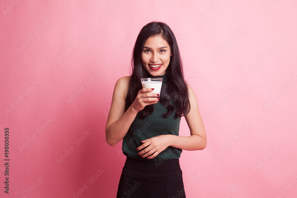 Healthy Asian woman drinking a glass of milk.