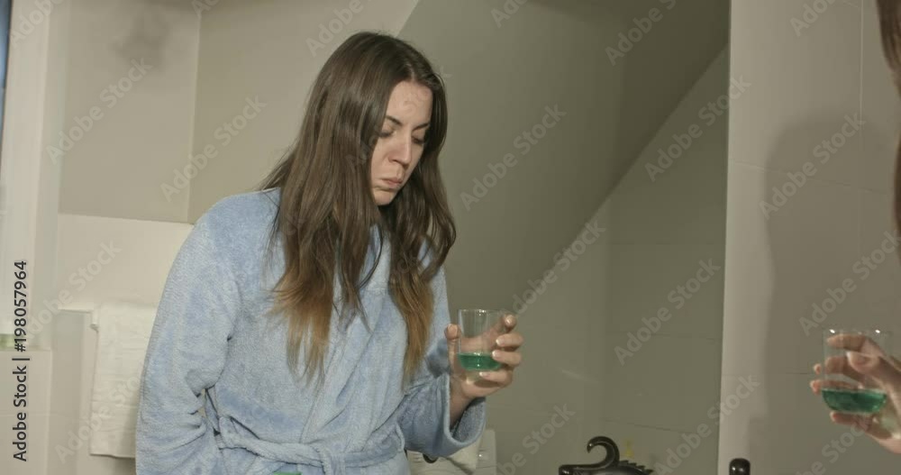 Casual woman washing her mouth with antiseptic liquid. Casual woman washing her mouth with antiseptic liquid.
