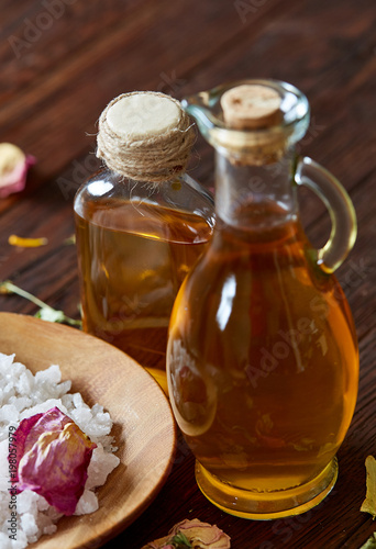 SPA concept: composition of spa treatment with natural sea salt, aromatic oil and flowers on wooden background