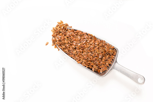 top view Organic flax seeds in iron scoop on white background