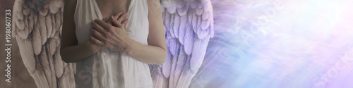 There is dark and light in all - Angel showing torso in white robes with hands held over heart with left side shaded in darkness and right side lit by a stream of heavenly white light
