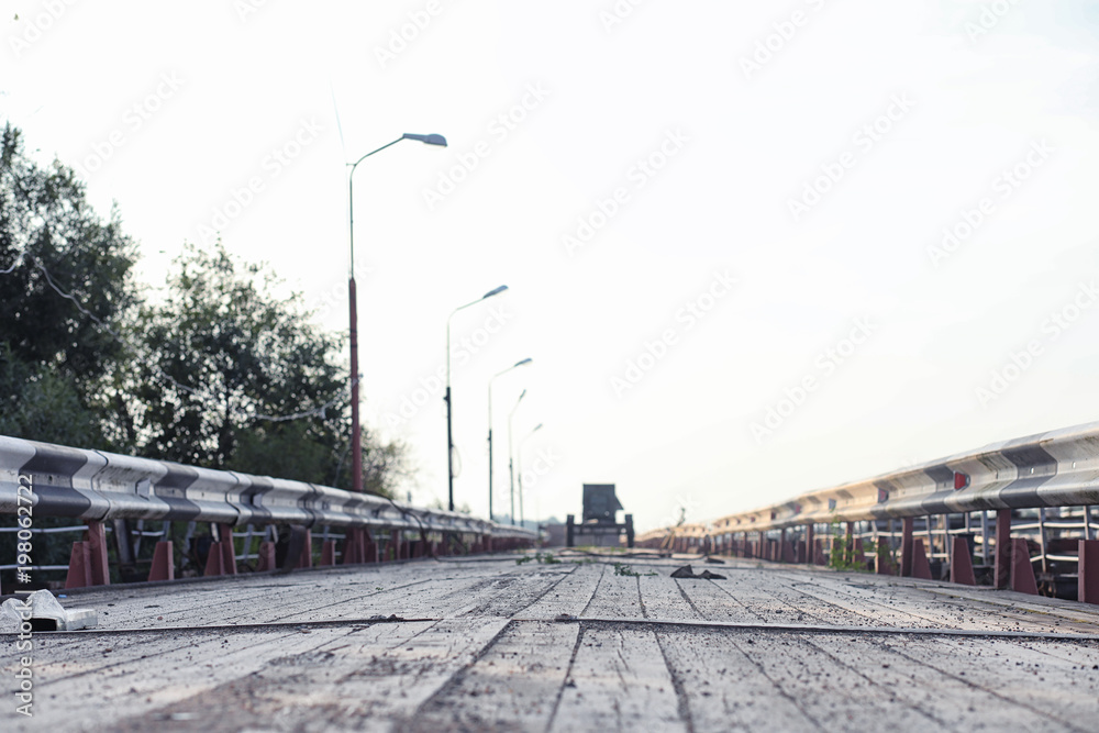 Wooden bridge on the river bank. A wooden road with pillars. Pan