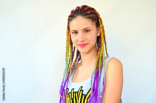 Девушка с модным набором разноцветных косичек Канекалон. Цветные искусственные пряди волос. Материал для плетения. © yuliyam