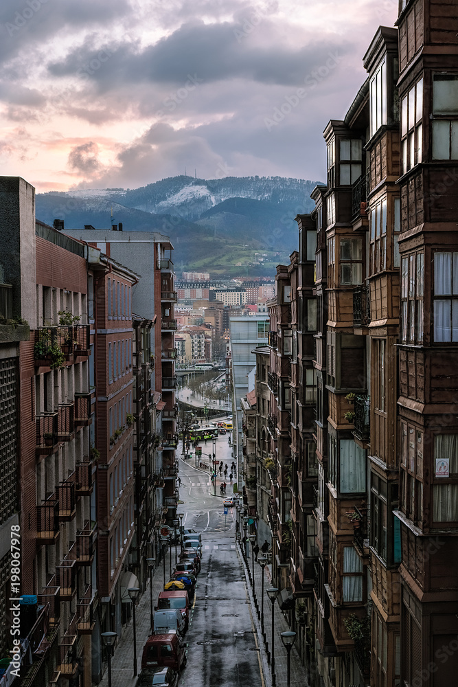 Fototapeta premium magical aerial view at sunset with reflections of the sun with the river and mountains in background in Bilbao. Spain
